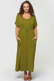 A model wearing the Mila Maxi Dress in colour Cardamom (Green), from the front, showing the whole outfit