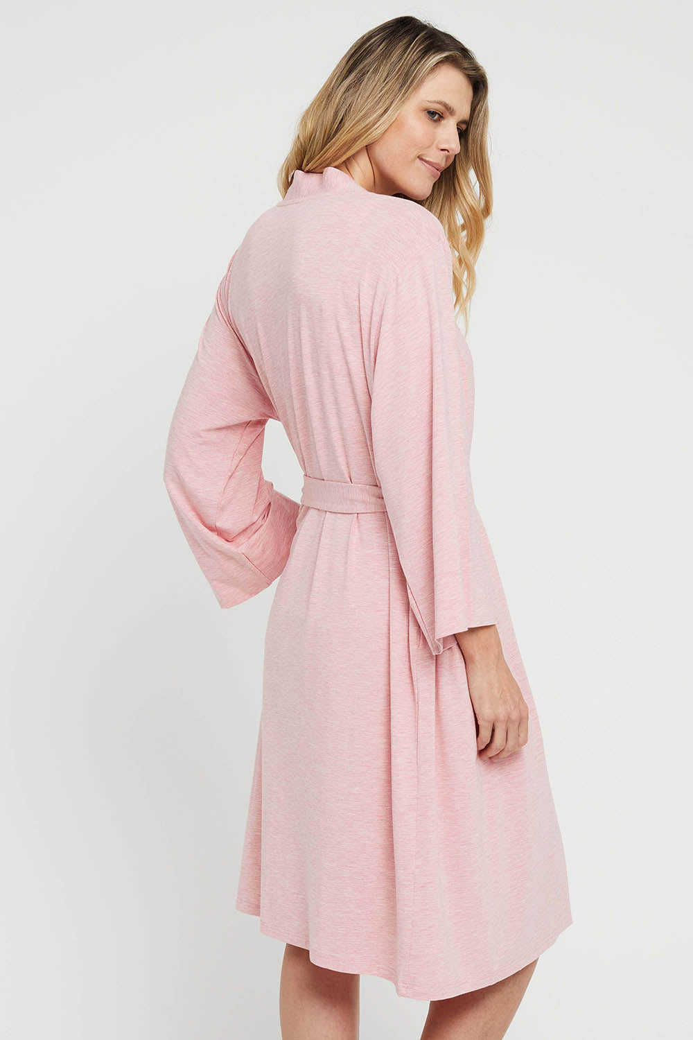 A model wearing the Bamboo Robe in colour Rose (Pink), from the back