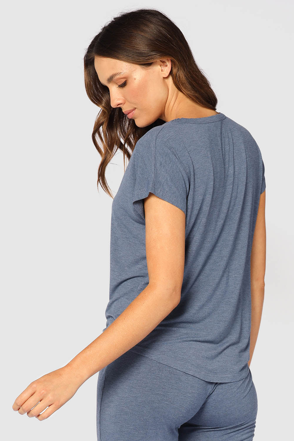 A model wearing the Lounge Bamboo Tee in colour Twilight (Blue), from the back