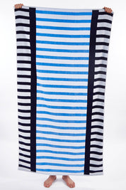 A model wearing size OneSize of the Egyptian Cotton Beach Towel in colour Coastline (Blue), from the front, showing the whole outfit