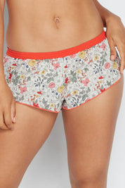 A model wearing the Liberty Bramble Short in colour Fiestabrum (Red), from the front, cropped image