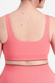 A model wearing the Act Seamless Scoop in colour Rosetea (Pink), from the back