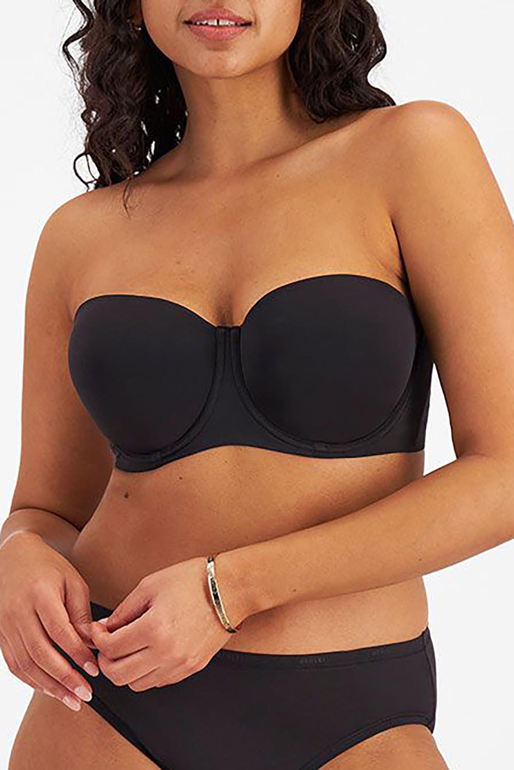A model wearing the Luminous Strapless Bra in colour Black (Black), from the front, cropped image