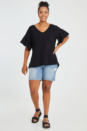 Model Noli wearing size 14 of the Alessi Frill Top in colour Black (Black), from the front, showing the whole outfit