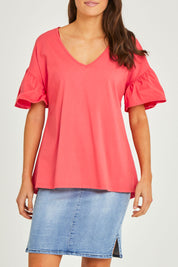 Model Elhana wearing size 10 of the Alessi Frill Top in colour Strawberry (Pink), from the front, cropped image