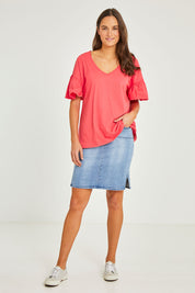Model Elhana wearing size 10 of the Alessi Frill Top in colour Strawberry (Pink), from the front, showing the whole outfit