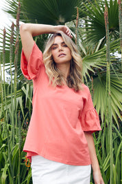 A model wearing the Alessi Frill Top in colour Strawberry (Pink), from the front, showing the whole outfit