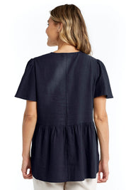 A model wearing the Abigail Blouse in colour Nigshadow (Blue), from the back