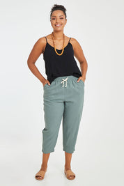 Model Noli wearing size 14 of the Lennon Pant in colour Deepgrn (Green), from the front, showing the whole outfit
