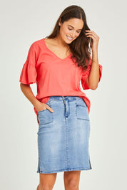Model Elhana wearing size 10 of the Avici Denim Skirt in colour Lightsky (Blue), from the front, cropped image