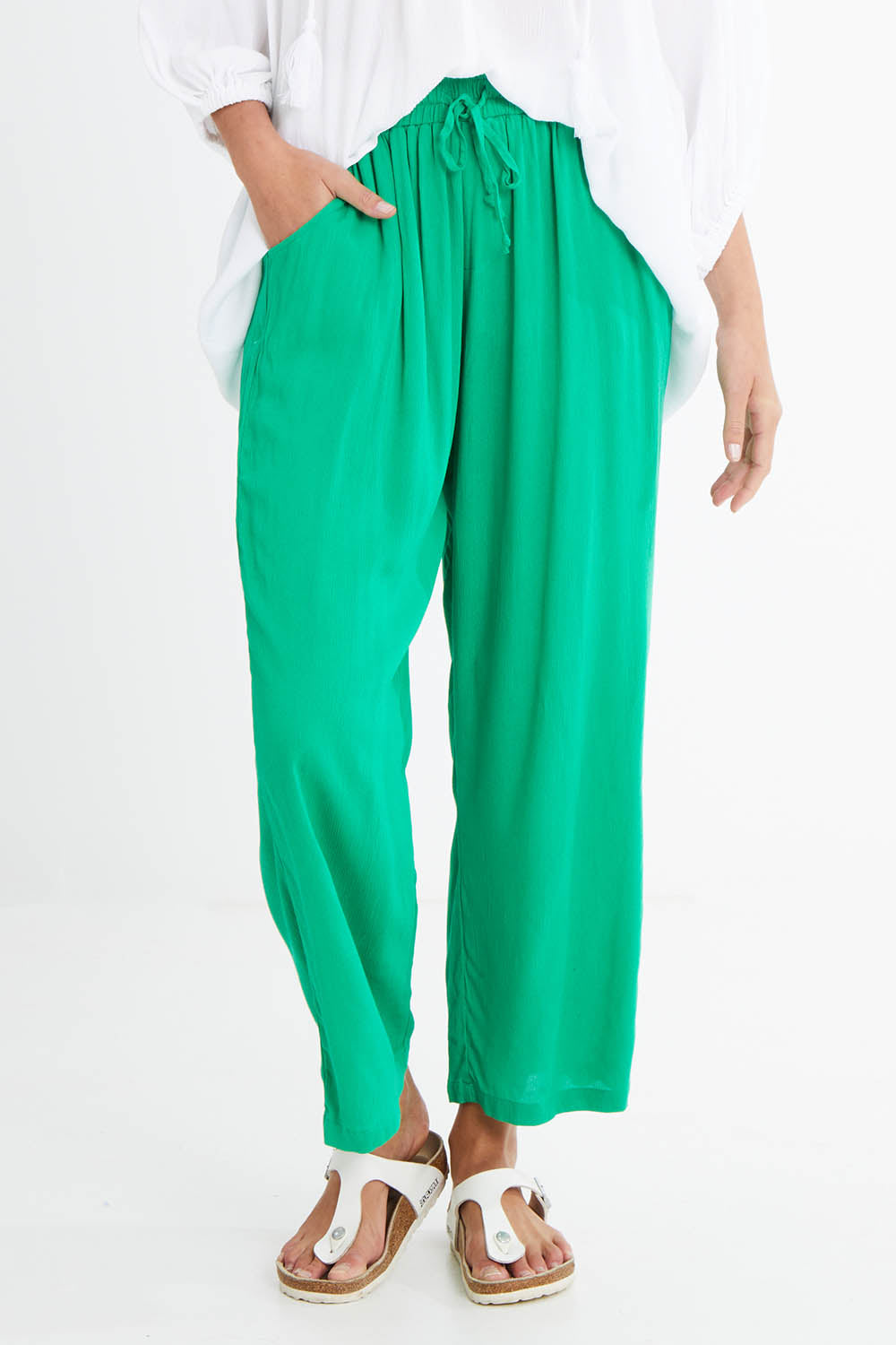 Model Madeline wearing size 10 of the Rani Pants in colour Green (Green), from the front, cropped image