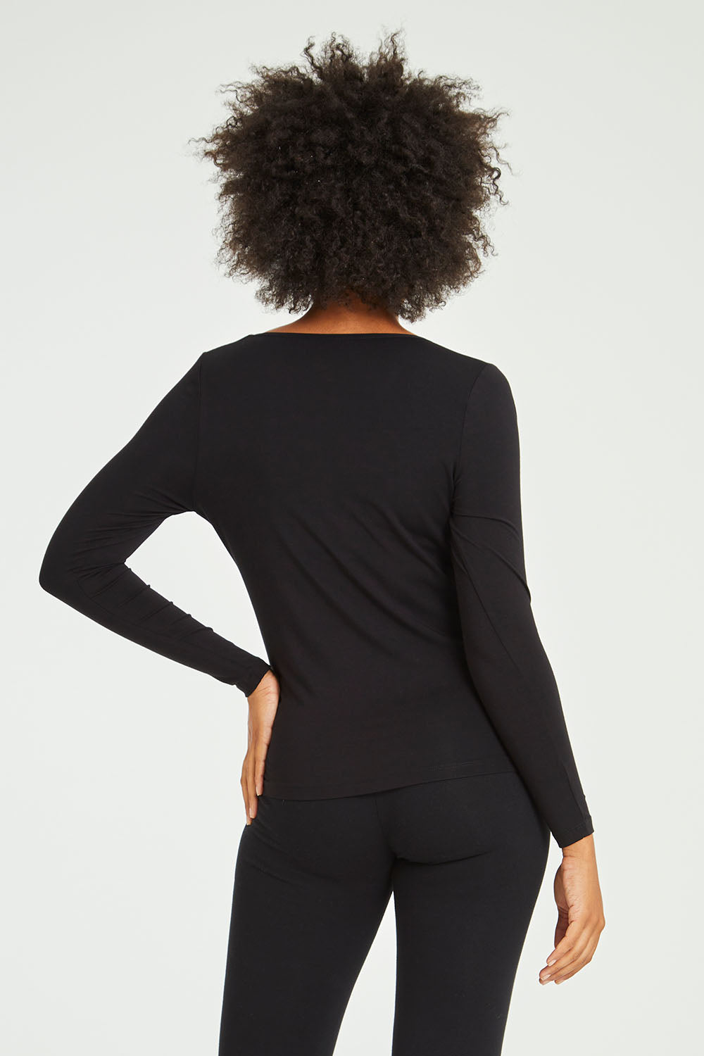 Model Olivia wearing size 10 of the Kelli Long Sleeve Top in colour Black (Black), from the back