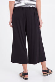 Model Madeline wearing size 10 of the Moulin Pant in colour Black (Black), from the back