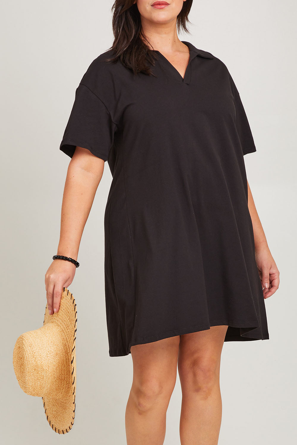 Model Poppy wearing size 16 of the Deana Polo Dress in colour Black (Black), from the front, cropped image