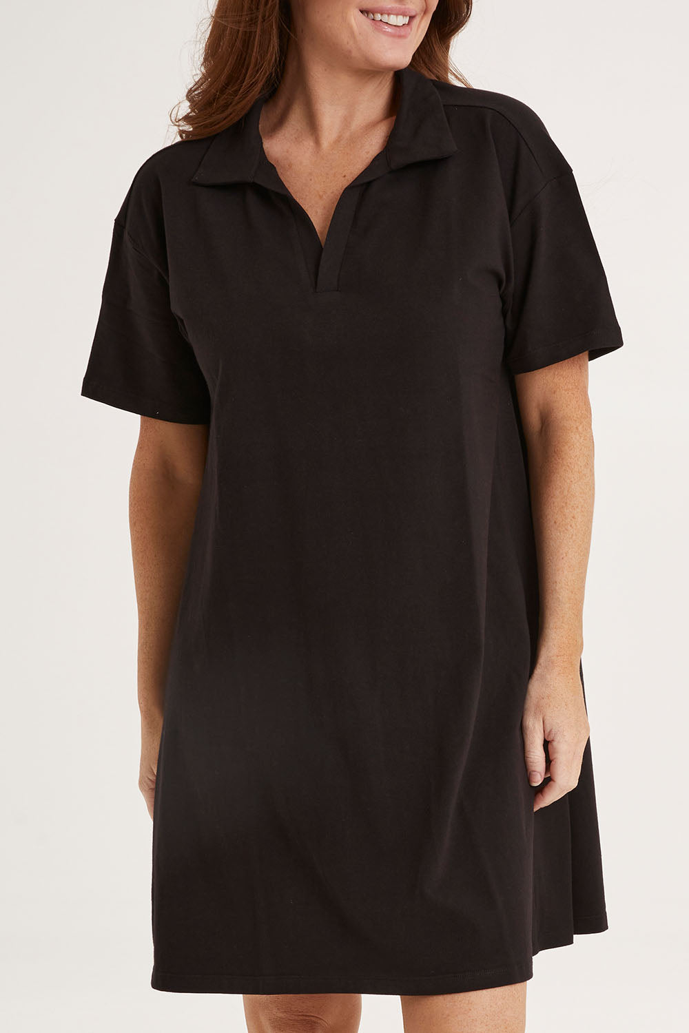 Model Sally wearing size 10 of the Deana Polo Dress in colour Black (Black), from the front, cropped image
