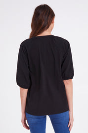 Model Madeline wearing size 10 of the Prue Tee in colour Black (Black), from the back