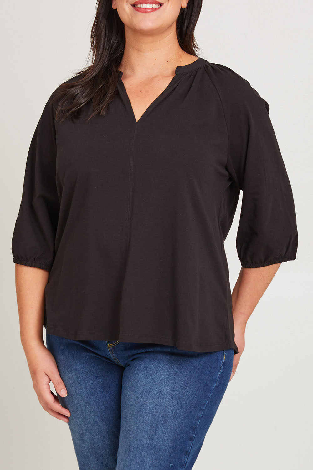 Model Poppy wearing size 16 of the Prue Tee in colour Black (Black), from the front, cropped image