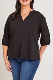 Model Poppy wearing size 16 of the Prue Tee in colour Black (Black), from the front, cropped image