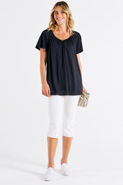 A model wearing the Coral Bamboo Shirred Tee in colour Black (Black), from the front, showing the whole outfit