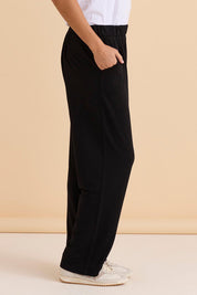 A model wearing the Ginnie Bamboo Pant in colour Black (Black), from the front, cropped image
