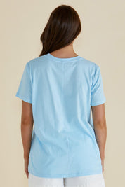 A model wearing the Ellia Cotton Crew Tee in colour Laplage (Blue), from the back