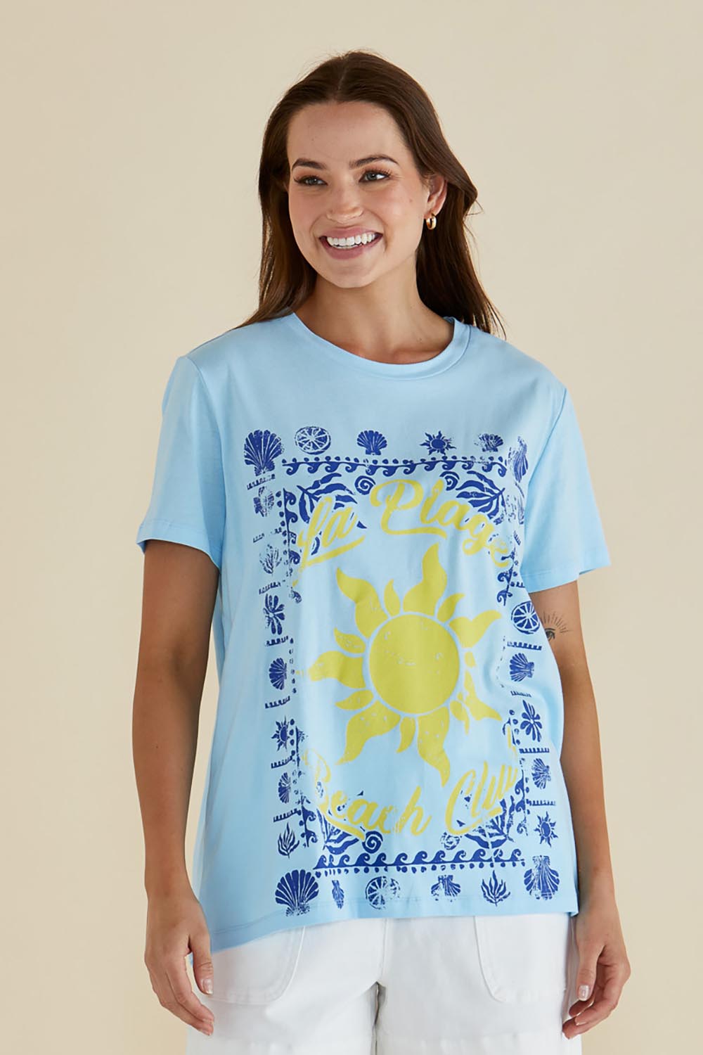 A model wearing the Ellia Cotton Crew Tee in colour Laplage (Blue), from the front, cropped image