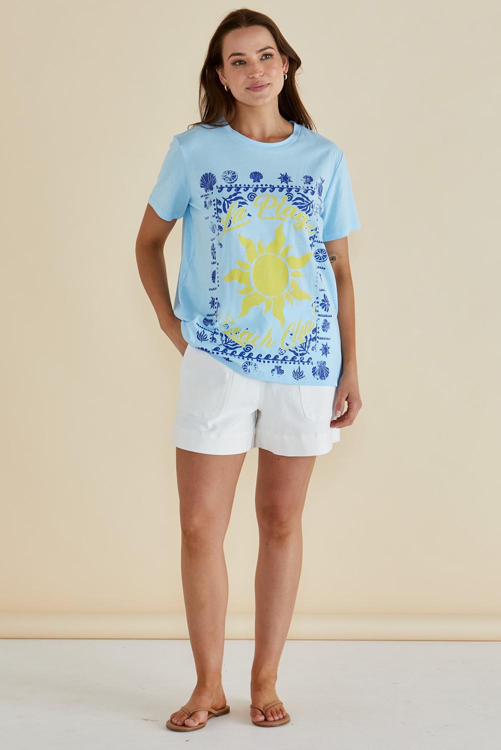 A model wearing the Ellia Cotton Crew Tee in colour Laplage (Blue), from the front, showing the whole outfit