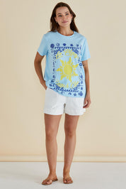 A model wearing the Ellia Cotton Crew Tee in colour Laplage (Blue), from the front, showing the whole outfit