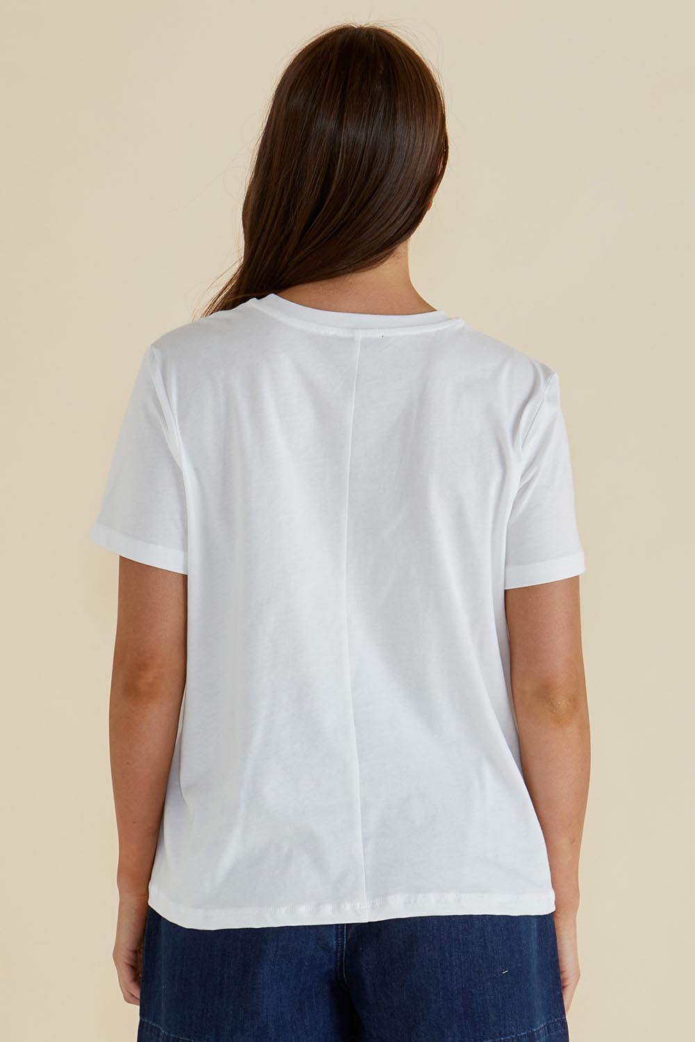 A model wearing the Ellia Cotton Crew Tee in colour Paradise (White), from the back