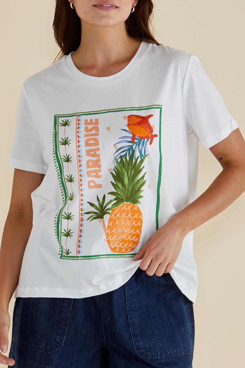 A model wearing the Ellia Cotton Crew Tee in colour Paradise (White), from the front, cropped image
