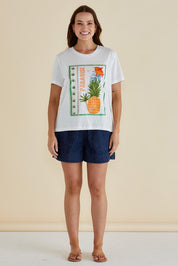 A model wearing the Ellia Cotton Crew Tee in colour Paradise (White), from the front, showing the whole outfit
