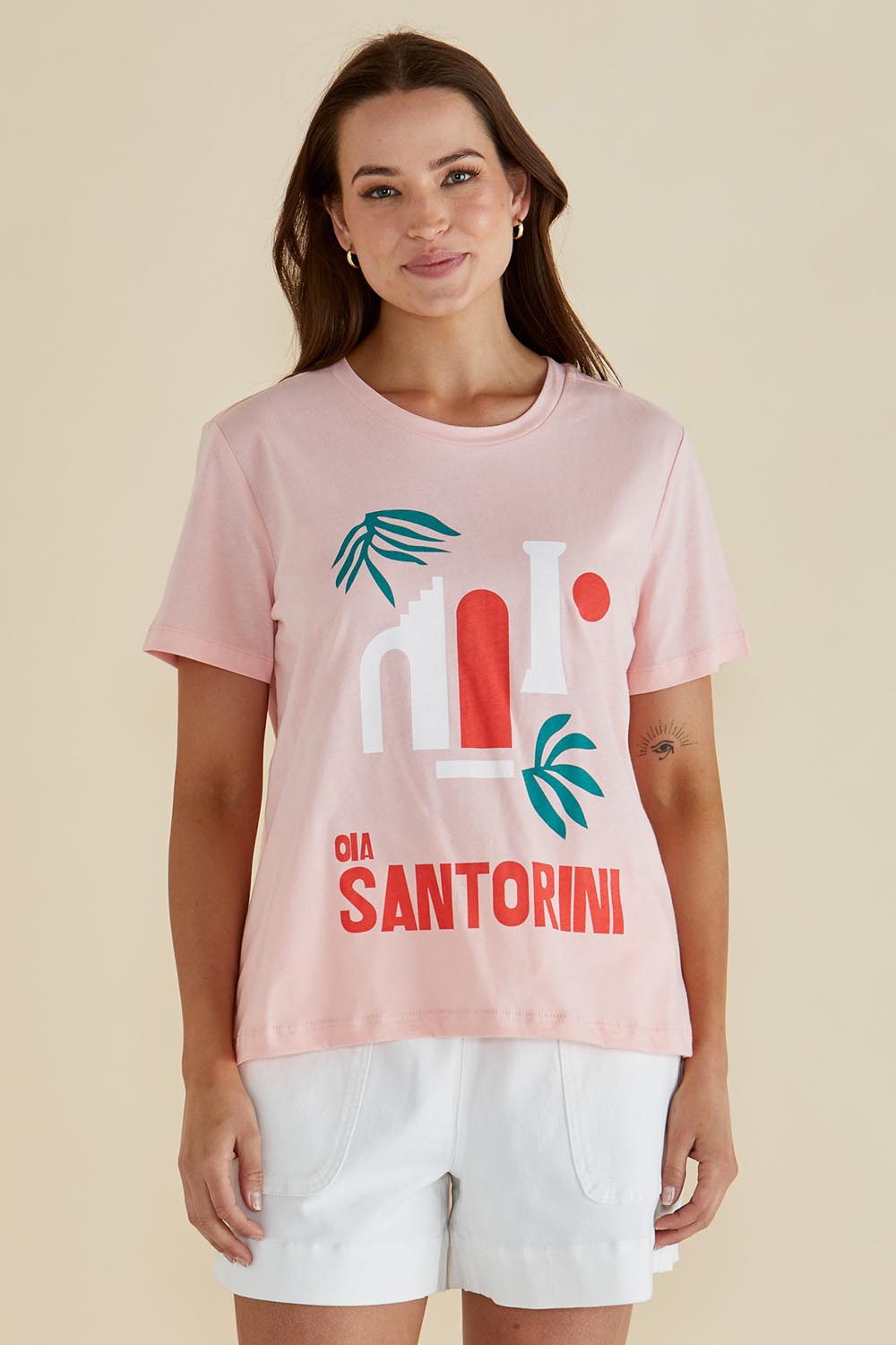 A model wearing the Ellia Cotton Crew Tee in colour Santorini (Pink), from the front, cropped image