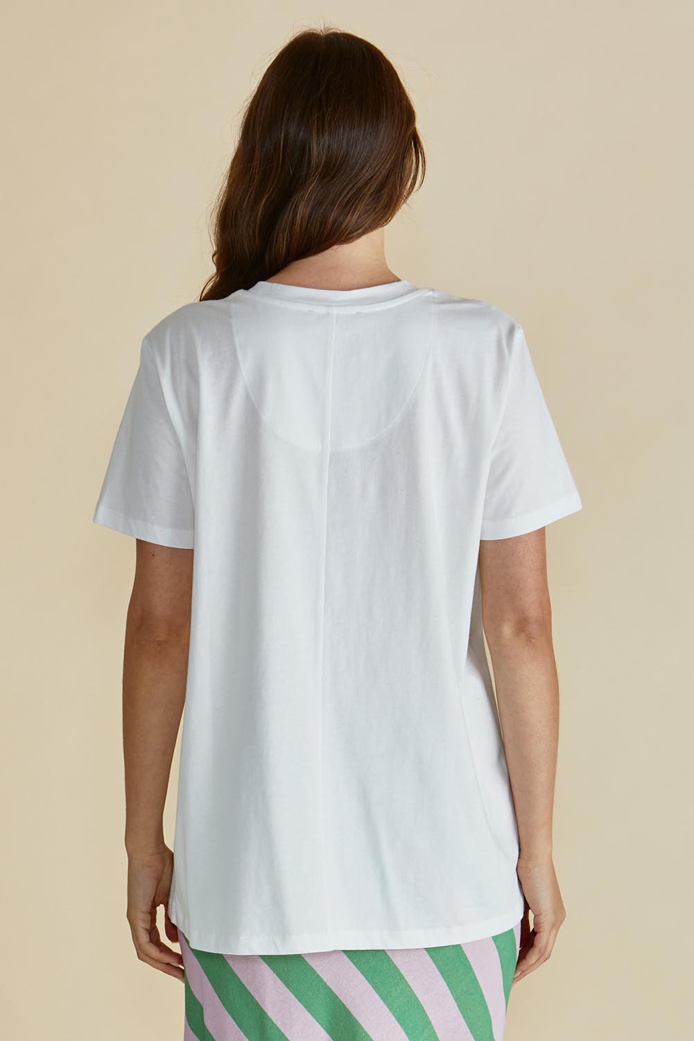 A model wearing the Ellia Cotton Crew Tee in colour Verao (Green), from the back