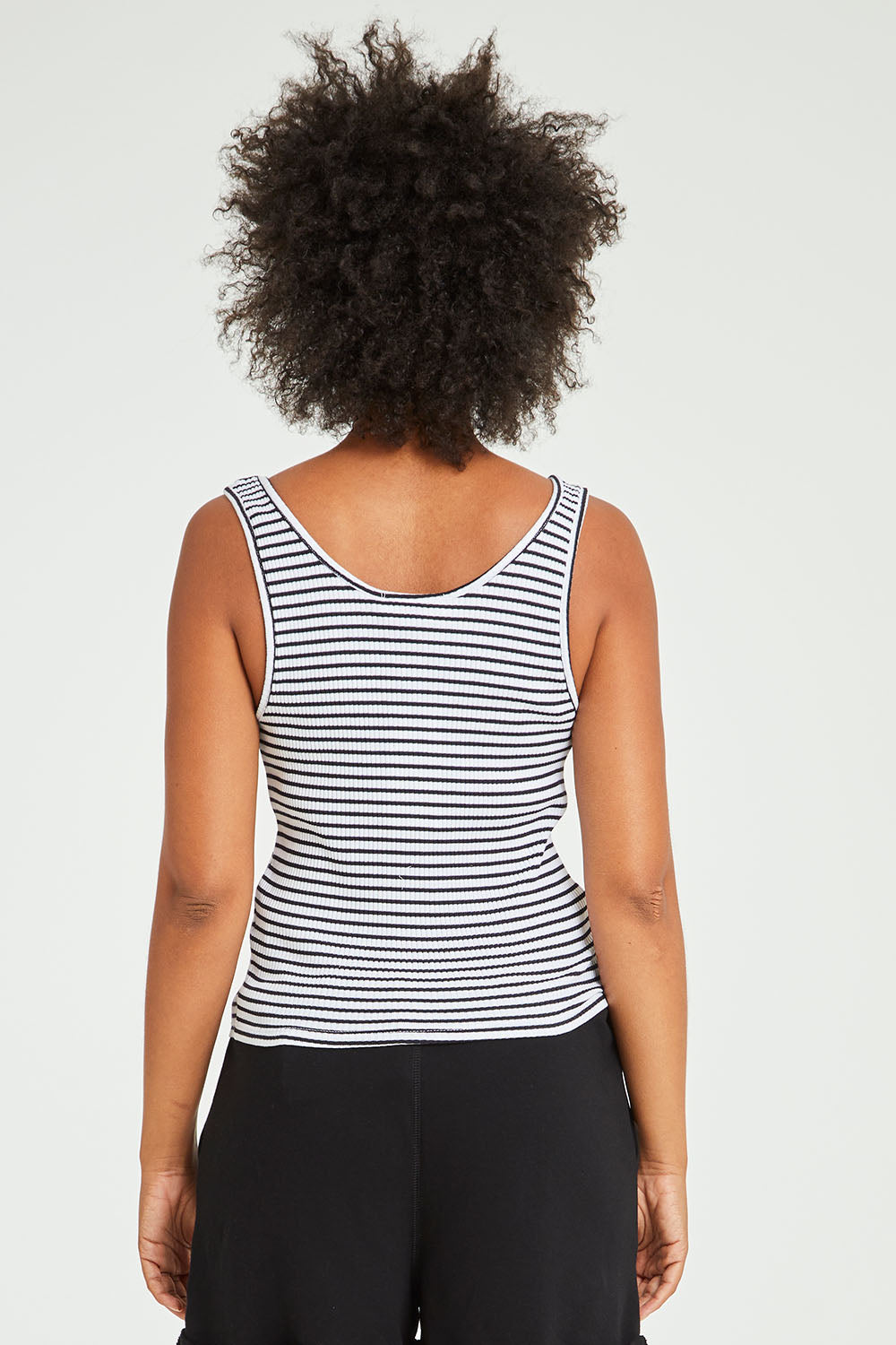 Model Olivia wearing size 10 of the Mimi Rib Tank in colour Whiteblack (White), from the back