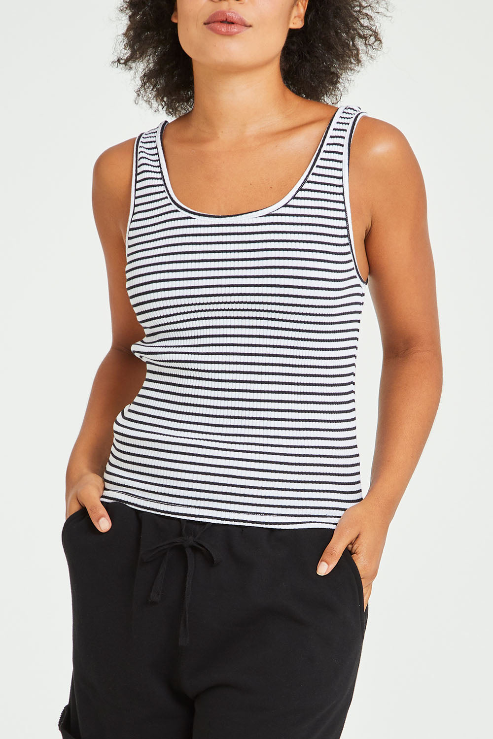Model Olivia wearing size 10 of the Mimi Rib Tank in colour Whiteblack (White), from the front, cropped image