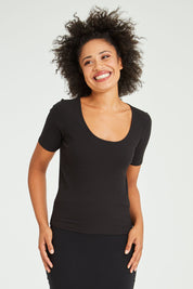 Model Olivia wearing size 10 of the Stacey Rib Tee in colour Black (Black), from the front, cropped image
