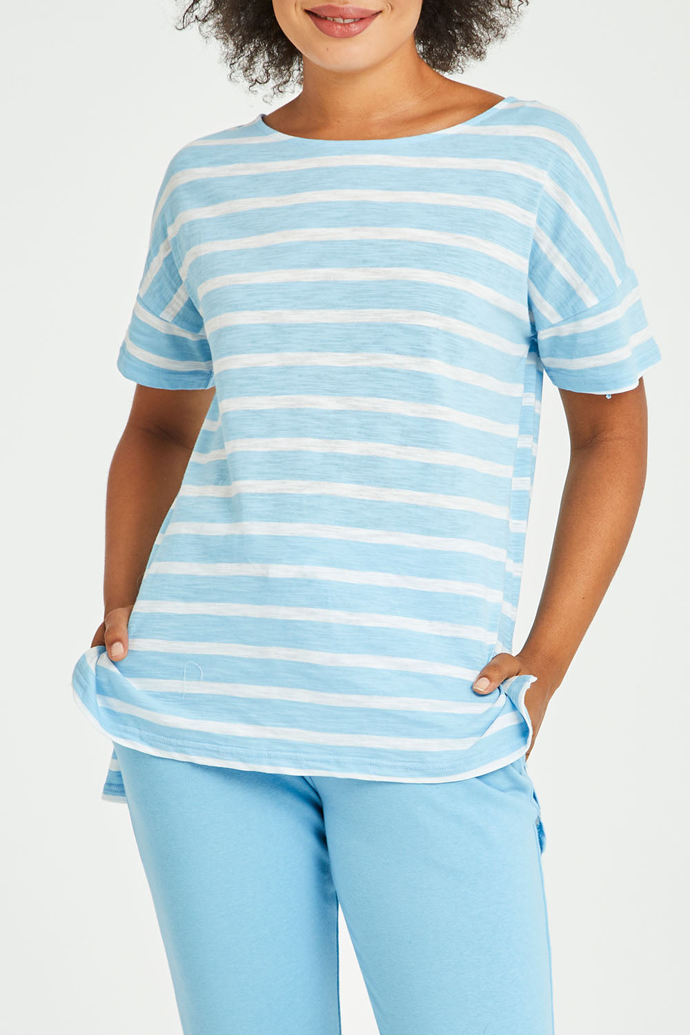 Model Olivia wearing size 10 of the Kathy Tee in colour Bluestripe (Blue), from the front, cropped image