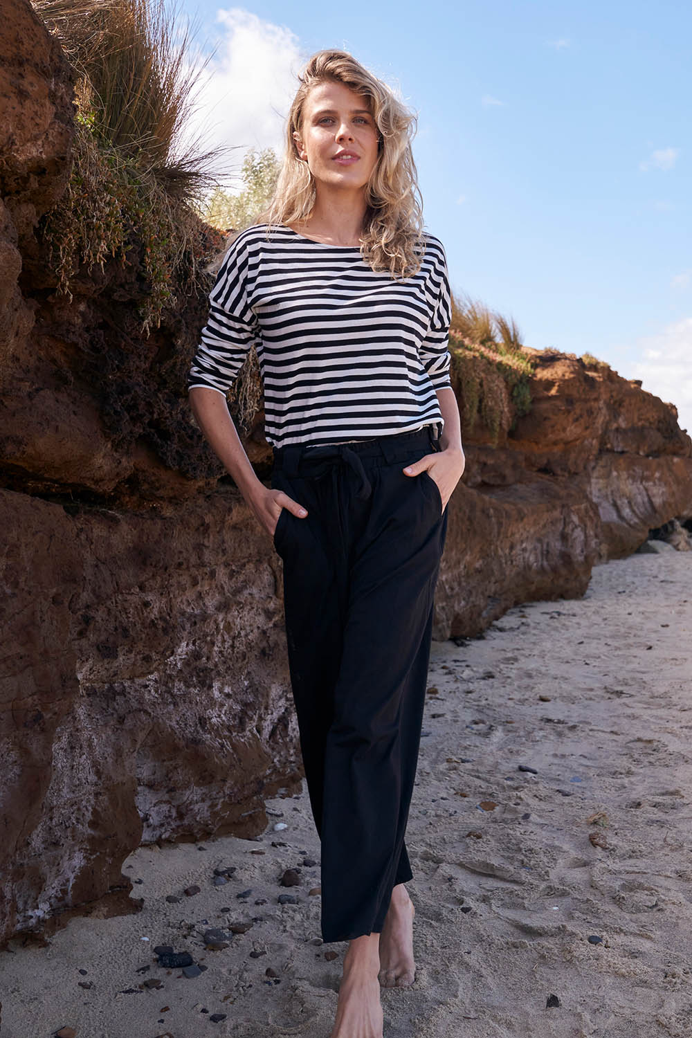 A model wearing the Dasha Pant in colour Black (Black), from the front, showing the whole outfit