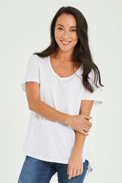 Model Katie wearing size 10 of the Ava Tee in colour White (White), from the front, cropped image