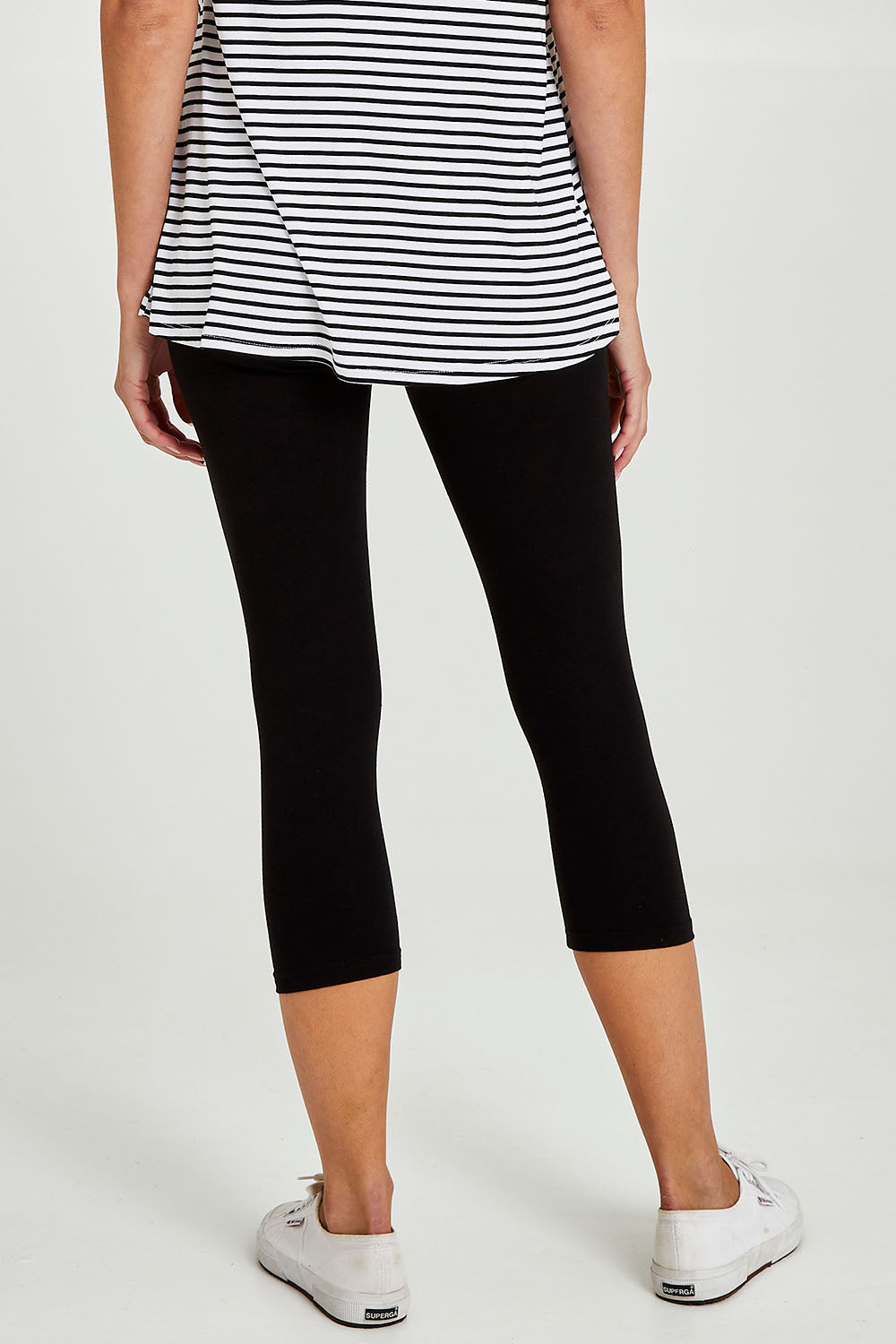 Model Madeline wearing size 10 of the Leia Crop Legging in colour Black (Black), from the back