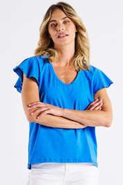 A model wearing the Magnolia Cotton Frill Sleeve Top in colour Powderblue (Blue), from the front, cropped image