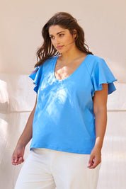 A model wearing the Magnolia Cotton Frill Sleeve Top in colour Powderblue (Blue), from the front, showing the whole outfit