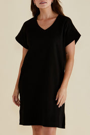 A model wearing the Elise V Neck Cotton Rib Dress in colour Black (Black), from the front, cropped image