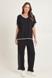 Model Madeline wearing size 10 of the Clara Tee in colour Black (Black), from the front, showing the whole outfit