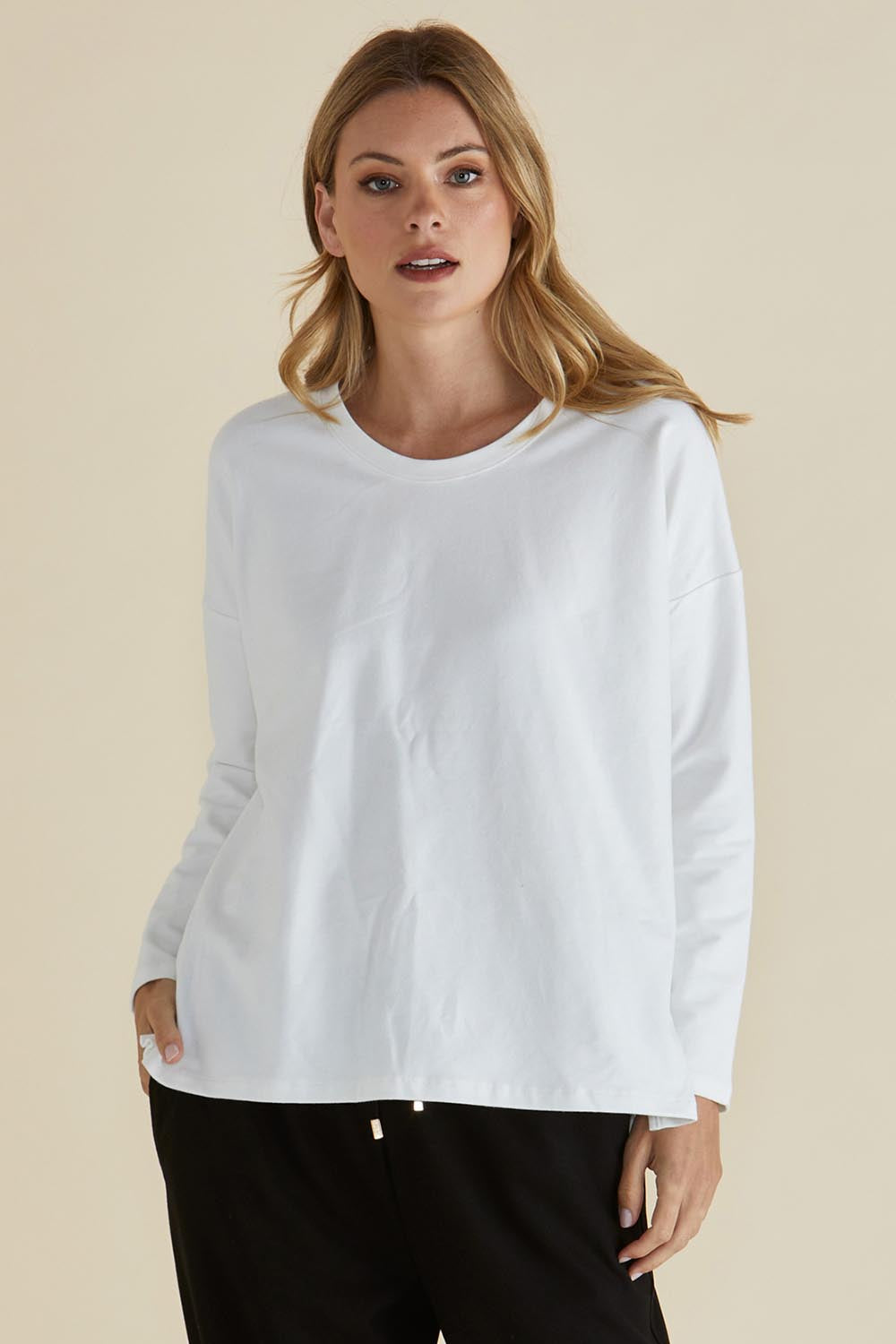 A model wearing the Brixley Long Sleeve Cotton Top in colour White (White), from the front, cropped image