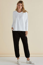 A model wearing the Brixley Long Sleeve Cotton Top in colour White (White), from the front, showing the whole outfit