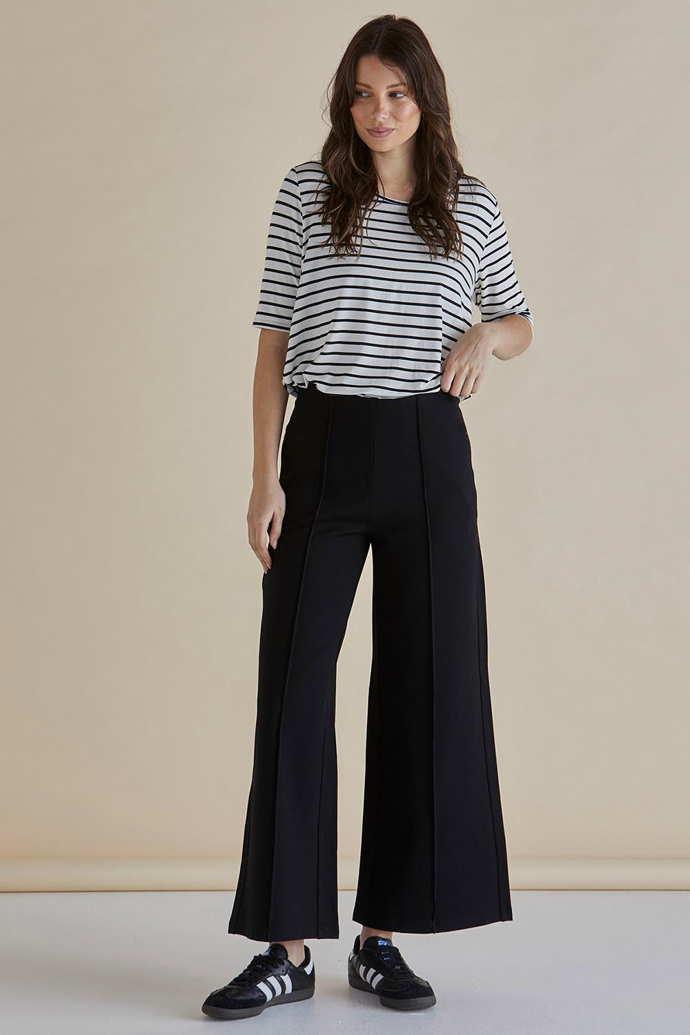 A model wearing the Elodie Wide Leg Ponte Pant in colour Black (Black), from the front, showing the whole outfit