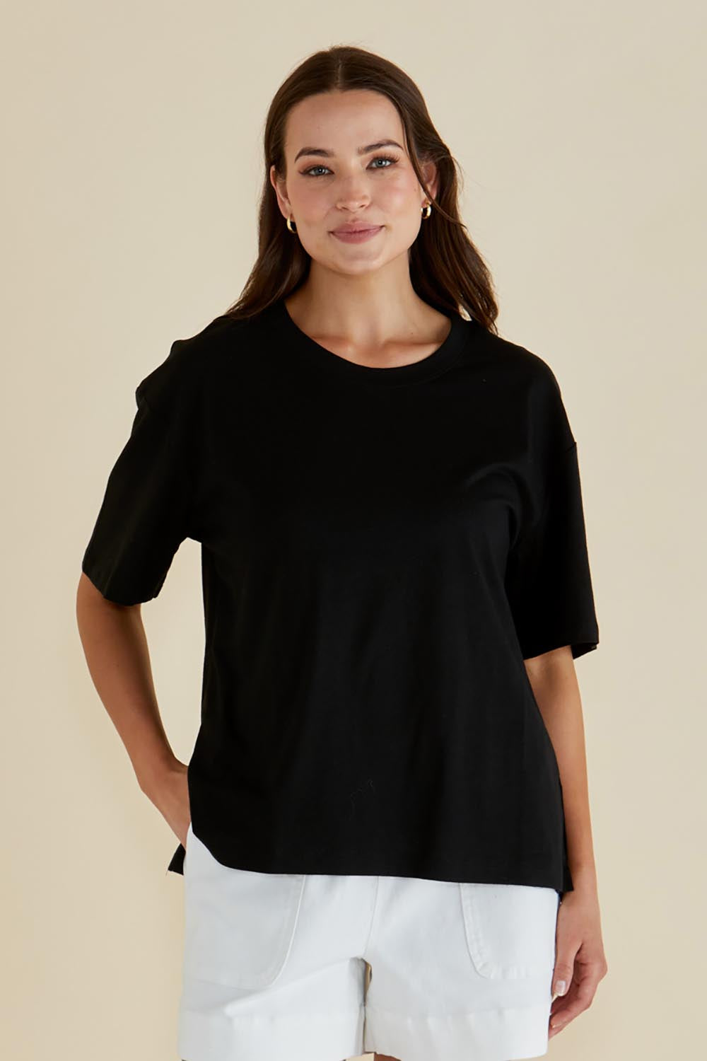 A model wearing the Relax Boxy Cotton Tee in colour Black (Black), from the front, cropped image