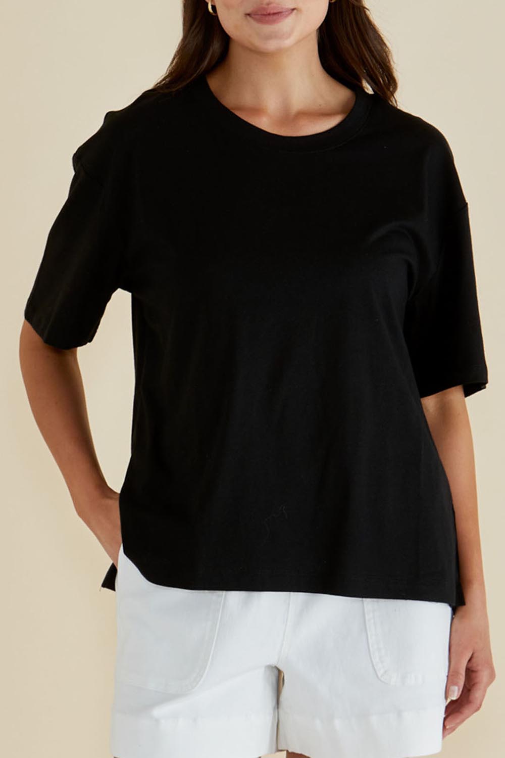 A model wearing the Relax Boxy Cotton Tee in colour Black (Black), from the front, cropped image