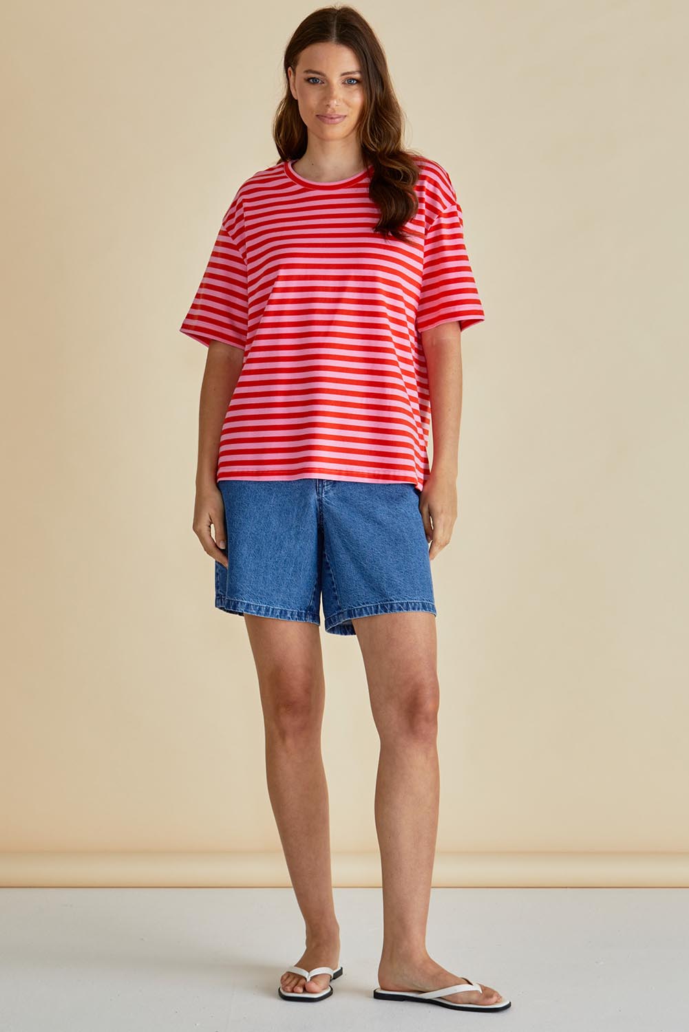 A model wearing the Relax Boxy Cotton Tee in colour Pinkred (Red), from the front, showing the whole outfit
